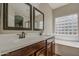 Bathroom featuring a dual sink vanity, soaking tub and shower with a glass block window for natural light at 1541 W Crape Rd, San Tan Valley, AZ 85140