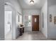 Bright foyer featuring neutral tile flooring, decorative accents and a wooden front door at 15492 W Whitton Ave, Goodyear, AZ 85395