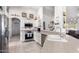 Well-lit kitchen with stainless steel appliances and white cabinets, open to the living room at 15492 W Whitton Ave, Goodyear, AZ 85395