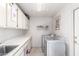 Bright laundry room with ample counter space, storage cabinets, and modern washer and dryer at 15492 W Whitton Ave, Goodyear, AZ 85395