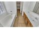 Bright bathroom featuring double sinks, granite countertops, soaking tub, and tile floors at 16370 W Rimrock St, Surprise, AZ 85388