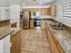 Well-lit kitchen boasts stainless appliances, granite countertops, tile floors and ample wood cabinetry at 16370 W Rimrock St, Surprise, AZ 85388