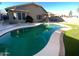 A backyard showcasing a pool with turf, landscaping, and a view of the home's exterior at 16370 W Rimrock St, Surprise, AZ 85388