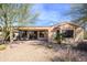 Backyard view of the covered patio area, desert landscaping, and view of the home at 16949 W Oasis Springs Way, Surprise, AZ 85387