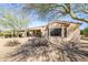 Back of house with covered patio, view of windows, desert landscaping, and low maintenance yard at 16949 W Oasis Springs Way, Surprise, AZ 85387