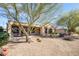 View of the backyard featuring desert landscaping, including a covered patio and barrel cactus at 16949 W Oasis Springs Way, Surprise, AZ 85387