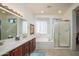 Main bathroom with dual sinks, soaking tub, and a separate glass enclosed shower at 16949 W Oasis Springs Way, Surprise, AZ 85387