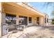 This covered patio features neutral color, outdoor seating, and access to the backyard at 16949 W Oasis Springs Way, Surprise, AZ 85387