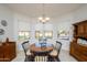 Cozy dining room featuring natural light, a round wood table, and wood furniture at 16949 W Oasis Springs Way, Surprise, AZ 85387