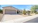 Spacious home featuring a large driveway, two-car garage and desert landscaping with mature trees at 16949 W Oasis Springs Way, Surprise, AZ 85387