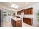 Bright kitchen features a skylight, wood cabinets, stainless steel appliances, and an island at 16949 W Oasis Springs Way, Surprise, AZ 85387