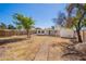 Backyard featuring mature shade trees, a rock path and view of the covered patio at 1716 W Weldon Ave, Phoenix, AZ 85015