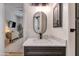 This bathroom has a dark vanity with a marble countertop and an oval mirror at 19864 E Via Del Oro --, Queen Creek, AZ 85142