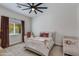 This bedroom has a ceiling fan, a neutral color scheme, and a window overlooking the yard at 19864 E Via Del Oro --, Queen Creek, AZ 85142