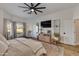 This main bedroom features wood floors, a ceiling fan, a TV, and a door to the outside at 19864 E Via Del Oro --, Queen Creek, AZ 85142