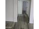 Hallway with wood-look floors leading to various rooms in the home at 21748 W Sonora St, Buckeye, AZ 85326