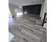 Open-concept living room showing wood-look flooring, a black accent wall, and natural light from windows at 21748 W Sonora St, Buckeye, AZ 85326