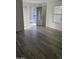 Bright living room showcasing wood-look flooring, a front door, and neutral walls bathed in natural light at 21748 W Sonora St, Buckeye, AZ 85326