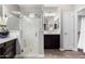 Modern bathroom featuring glass-enclosed shower, dark wood vanity, and tile flooring at 22754 W Moonlight Path, Buckeye, AZ 85326