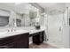 Bright bathroom featuring a glass shower and a vanity with dark cabinets and a white countertop at 22754 W Moonlight Path, Buckeye, AZ 85326