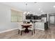 Cozy dining room adjacent to kitchen features modern lighting and wood-look tile flooring at 22754 W Moonlight Path, Buckeye, AZ 85326