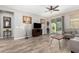 Living room featuring wood-look flooring, sliding glass door access to patio, and contemporary furnishings at 22754 W Moonlight Path, Buckeye, AZ 85326