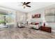 Bright living room with neutral decor, wood-look tile flooring, and sliding glass door to the backyard at 22754 W Moonlight Path, Buckeye, AZ 85326