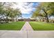 Serene outdoor space with a brick walkway, lush green grass, and mature trees for relaxation at 2425 W Bronco Butte Trl # 2024, Phoenix, AZ 85085