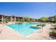 Community pool surrounded by landscaping, lounge chairs, and umbrellas at 2425 W Bronco Butte Trl # 2030, Phoenix, AZ 85085