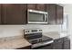 Close up view of stainless steel microwave and cooktop, and granite countertops at 24653 W Concorda Dr, Buckeye, AZ 85326