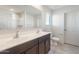 Bathroom with double sink vanity, large mirror, and a tiled floor at 2528 S 244Th Dr, Buckeye, AZ 85326