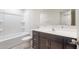 This bathroom features a shower and tub, a dark vanity and a white toilet at 2528 S 244Th Dr, Buckeye, AZ 85326