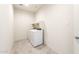 Neat laundry room has washer, dryer, white cabinets and tiled floors at 2544 S 244Th Dr, Buckeye, AZ 85326