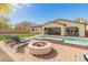 Spacious backyard with a pool, patio, fire pit, and ample seating for outdoor entertaining and relaxation at 30259 N 125Th Ln, Peoria, AZ 85383