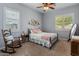 Cozy bedroom with soft carpet, rocking chair, and neutral color scheme at 30259 N 125Th Ln, Peoria, AZ 85383