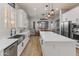 Bright white kitchen with stainless appliances, modern fixtures, and a large center island at 30259 N 125Th Ln, Peoria, AZ 85383