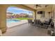 Covered patio featuring comfortable seating, an outdoor television, and a view of the backyard pool area at 30259 N 125Th Ln, Peoria, AZ 85383