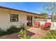 Charming patio with two wicker chairs, lush landscaping, and red accents at 318 E Concorda Dr, Tempe, AZ 85282