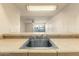 View from kitchen bar into living area featuring tile countertop and stainless steel sink at 3313 N 68Th St # 111, Scottsdale, AZ 85251