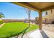 View of the backyard with green grass, covered patio, playground set, and trampoline for outdoor fun at 33731 N Slate Creek Dr, San Tan Valley, AZ 85143