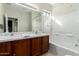 Bright bathroom with a dual sink vanity, tile countertops, and a shower/tub combo at 33731 N Slate Creek Dr, San Tan Valley, AZ 85143