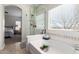 Bright bathroom featuring tiled flooring, a soaking tub, and walk-in shower with glass enclosure at 33731 N Slate Creek Dr, San Tan Valley, AZ 85143