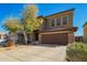 View of the home's two-car garage, neutral stucco, and desert landscaping at 33731 N Slate Creek Dr, San Tan Valley, AZ 85143