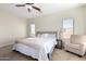 Spacious main bedroom featuring a bed, seating area, neutral carpet, and a ceiling fan at 33731 N Slate Creek Dr, San Tan Valley, AZ 85143