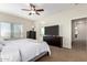 Main bedroom with a ceiling fan, dresser, neutral carpet, and a view into the ensuite bathroom at 33731 N Slate Creek Dr, San Tan Valley, AZ 85143