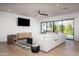 Modern living room featuring a large sliding glass door, a comfortable white sofa, and stylish hardwood floors at 3628 E Clarendon Ave, Phoenix, AZ 85018