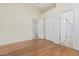 Empty bedroom with hardwood floors, white walls, and two closet doors at 3887 E Andre Ave, Gilbert, AZ 85298