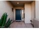 A beautifully decorated entryway with a dark teal front door and decorative potted plants at 3887 E Andre Ave, Gilbert, AZ 85298