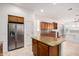 Kitchen featuring stainless steel refrigerator, island with granite countertop, and wood cabinetry at 3887 E Andre Ave, Gilbert, AZ 85298