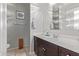 Bright bathroom featuring a dark wood vanity cabinet, large mirror, and tiled flooring at 3973 N 310Th Ln, Buckeye, AZ 85396